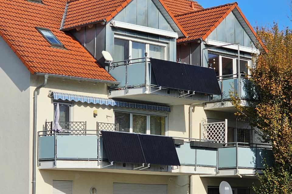 A plug-in solar panel fixed to the railing of a balcony